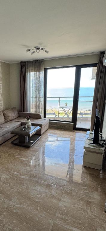 a living room with a couch and a view of the ocean at Infinity Sea View Deluxe Apartment in Pomorie