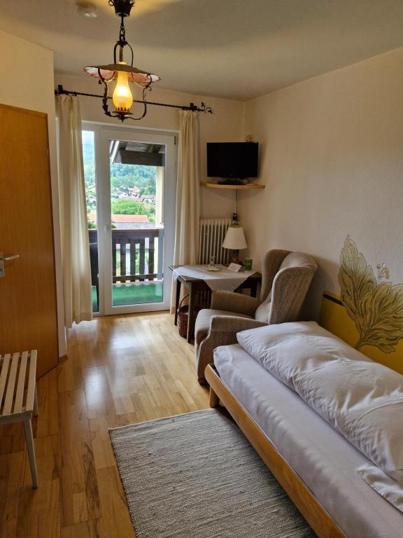 a living room with a couch and a chair at Hotel Garni Tonihof in Eschenlohe