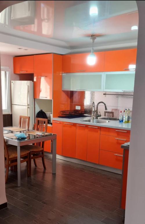 a kitchen with orange cabinets and a table with chairs at BlueStay in Qiryat Yam