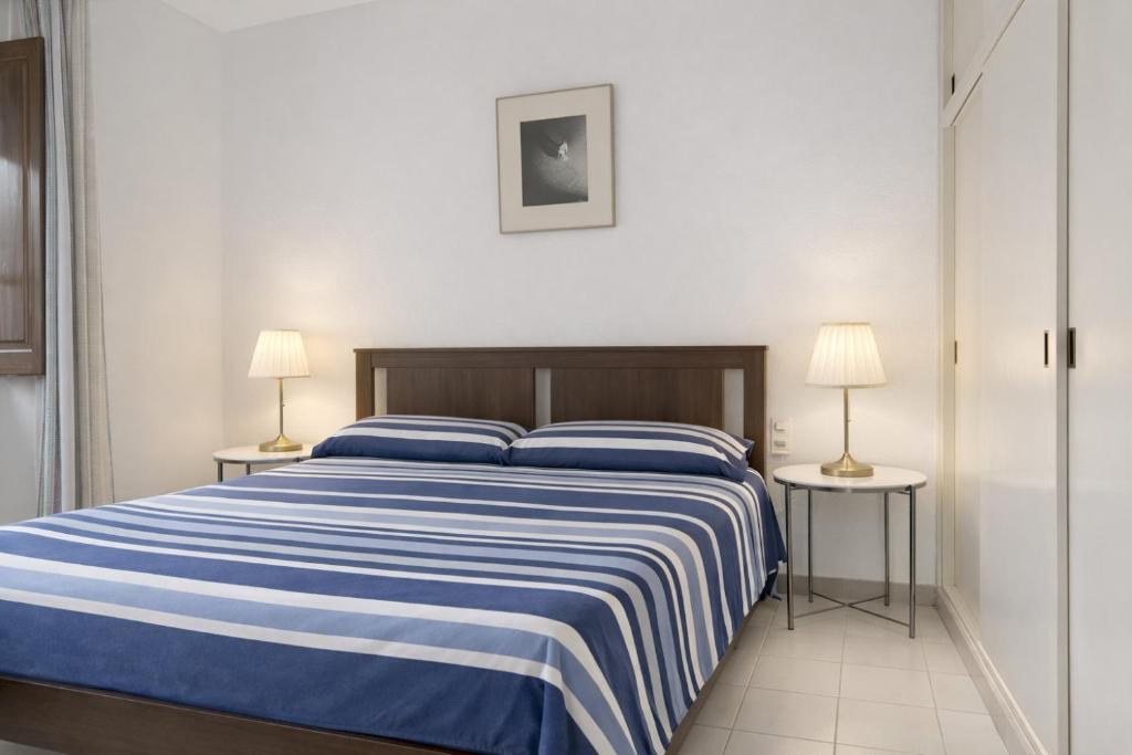 ein Schlafzimmer mit einem blau-weißen Bett und zwei Lampen in der Unterkunft Ca La Roseta in Castellfollit de la Roca
