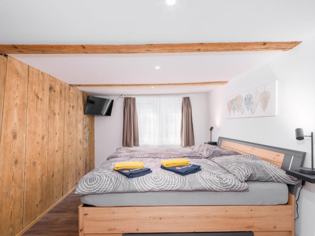 a bedroom with a large bed with yellow cushions at Private Rooms near Glarus, Shared Bath in Näfels