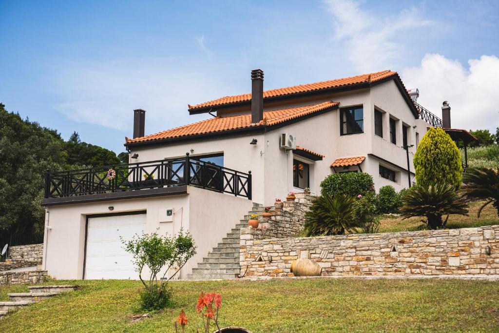 a white house with a garage on a stone wall at Petra Kazarma in Kymi