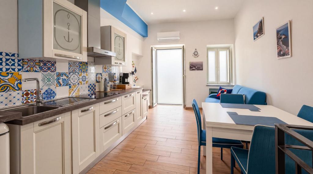 a kitchen with a sink and a table with blue chairs at Rifugio Del Generale - comfort & relax in Pizzo
