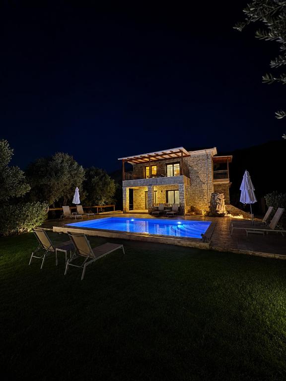 a house with a swimming pool at night at Iris Villas Complex in Lefkada