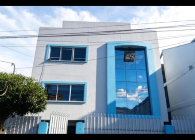 a house with blue windows and a white fence at Amplio y elegante monoambiente , de lujo in La Paz