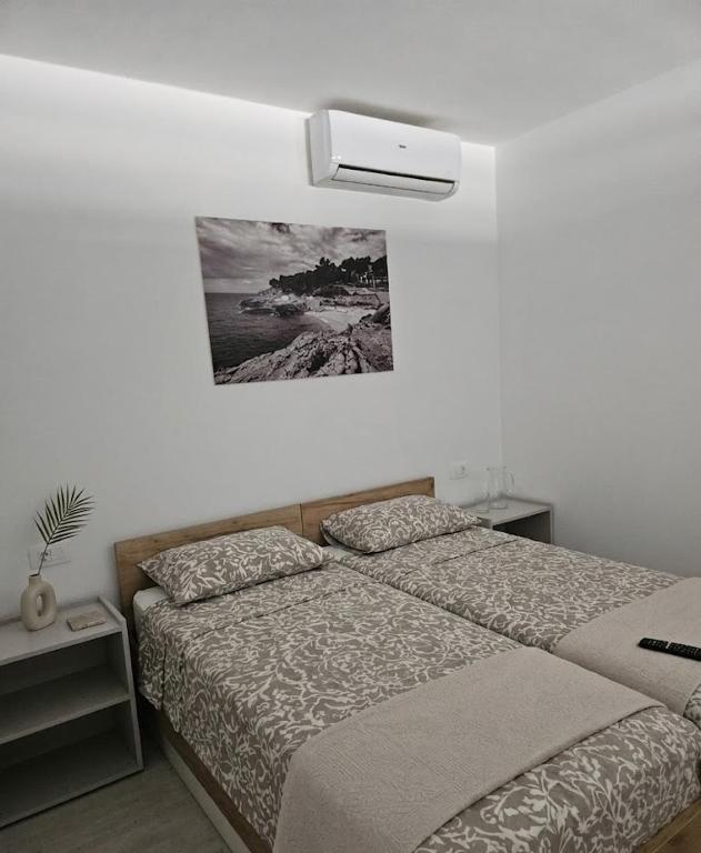 a bedroom with two beds and a picture on the wall at Villa Mirakul in Vir