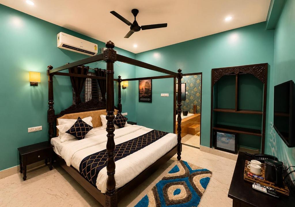 a bedroom with a canopy bed with a ceiling fan at Arka by Utkalio in Puri
