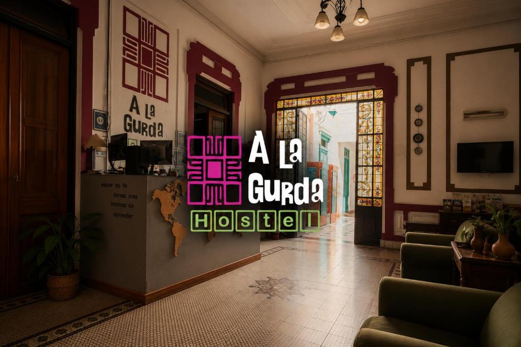 a room with a door with a sign that reads a la guadalupe at A la Gurda Hostel - Barrio Norte in San Miguel de Tucumán