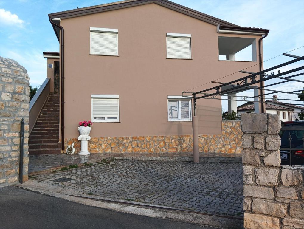a house with a vase of flowers in front of it at Apartment Alina in Umag
