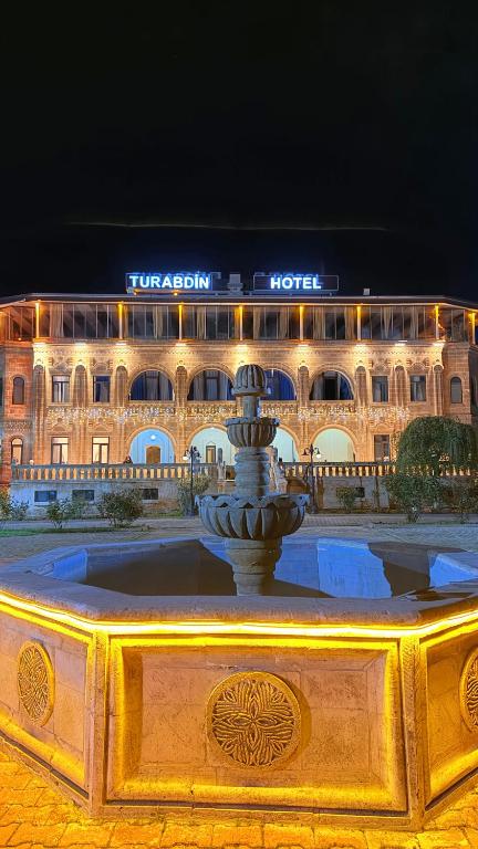 ein großes Gebäude mit einem Brunnen vor einem Gebäude in der Unterkunft Turabdin Hotel in Midyat
