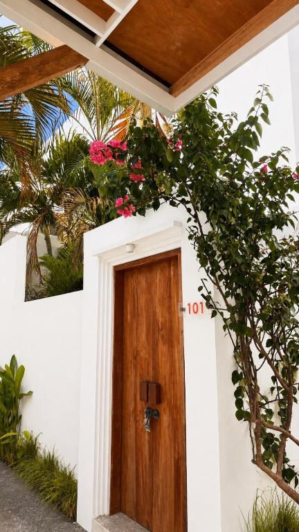 a house with a wooden door with flowers on it at La Belle Villa in Seminyak