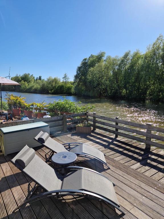 a dock with a table and chairs on the water at Watercabin in Ooltgensplaat in Ooltgensplaat