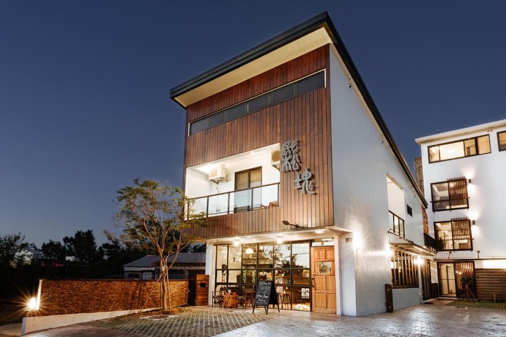 een groot wit gebouw met een houten gevel bij Chillax Inn B&B in Hengchun