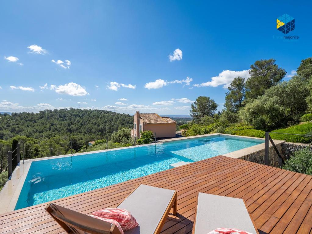 a villa with a swimming pool and a wooden deck at Villa Cata in Esporles