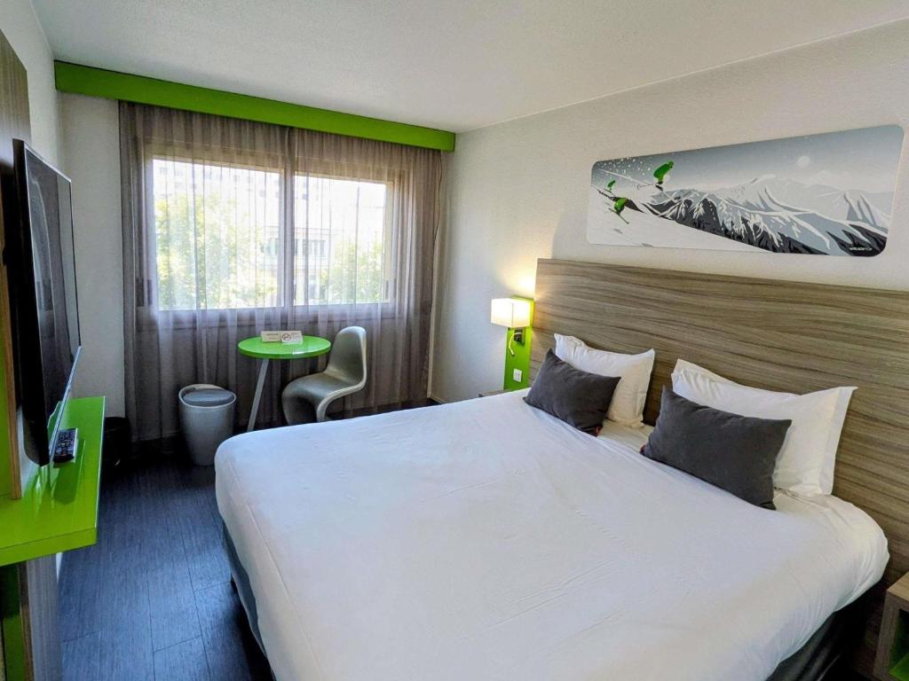 a hotel room with a large bed and a television at ibis Styles Grenoble Centre Gare in Grenoble