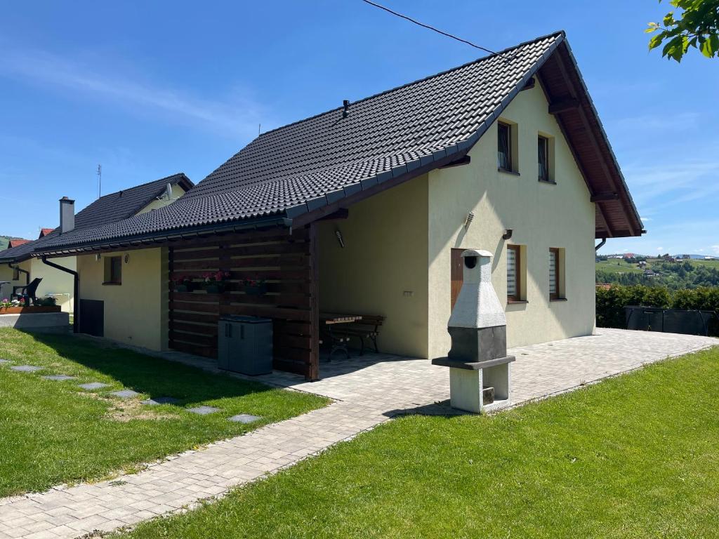 a small white building with a black roof at Domki pod Beskidem in Jaworzynka