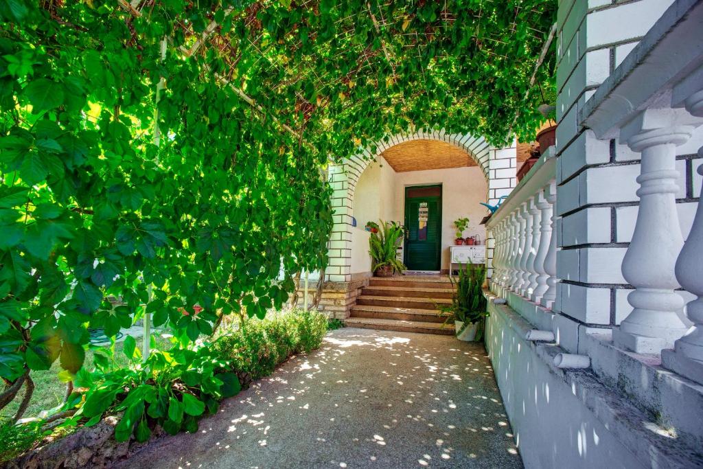an archway leading to a house with a door at Apartmani Juricev Vodice in Vodice