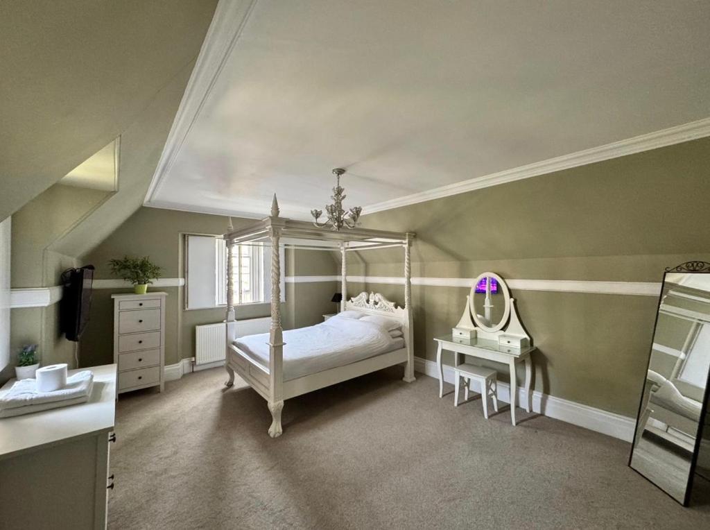 a bedroom with a canopy bed and a mirror at West End Beds in Dundee