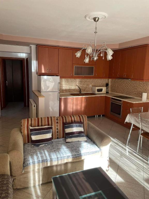a living room with a couch and a kitchen at mema apartment in Nea Peramos