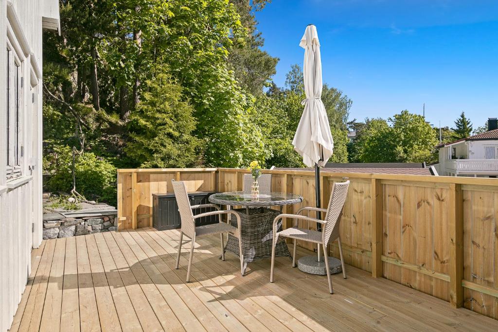 a patio with a table and chairs and an umbrella at Hagehuset in Kragerø