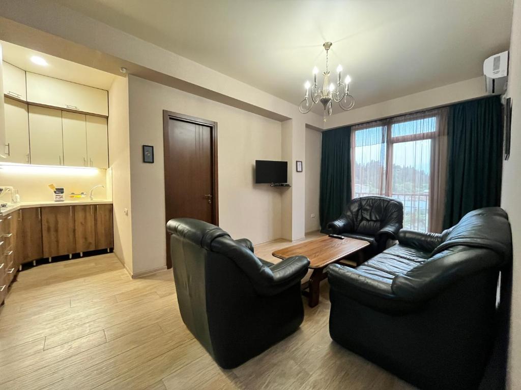 a living room with black leather chairs and a table at Dadiani Apartment in Tbilisi City