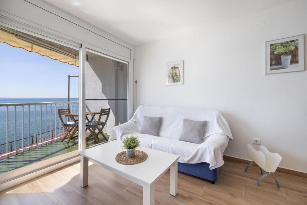 a living room with a couch and a balcony at Apartament Platja L'arquitecte in L'Ampolla