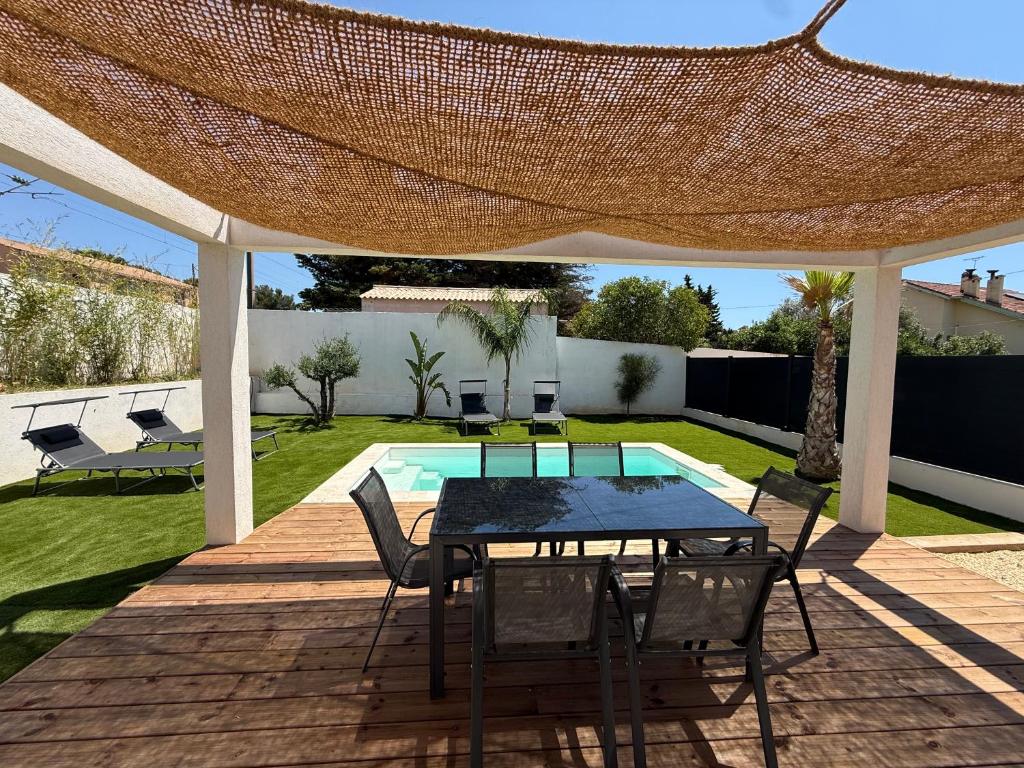 a patio with a table and chairs and a pool at Villa ROC in Bandol