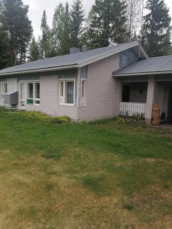 a house with a grass yard in front of it at puominmutka in Ilomantsi