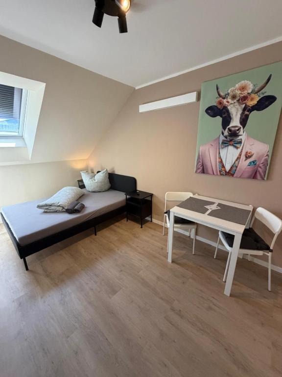 a bedroom with a bed and a table and a giraffe painting at NB14-1 Living in Weingarten (Karlsruhe)
