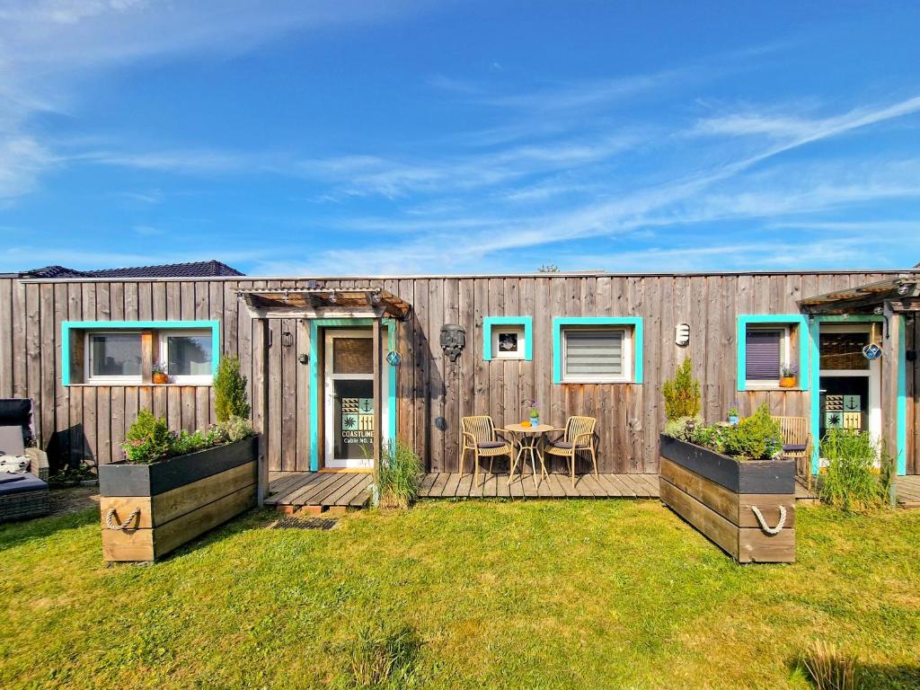 a wooden house with a table in a yard at Coastline Apartments in Fuhlendorf