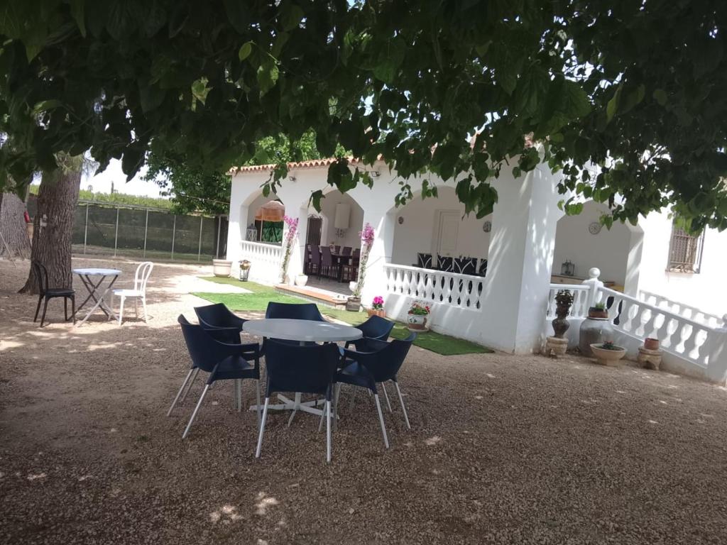 a table and chairs in front of a white house at Rustic Chalet With Easy Golf Beach Access Oliva Nova in Oliva