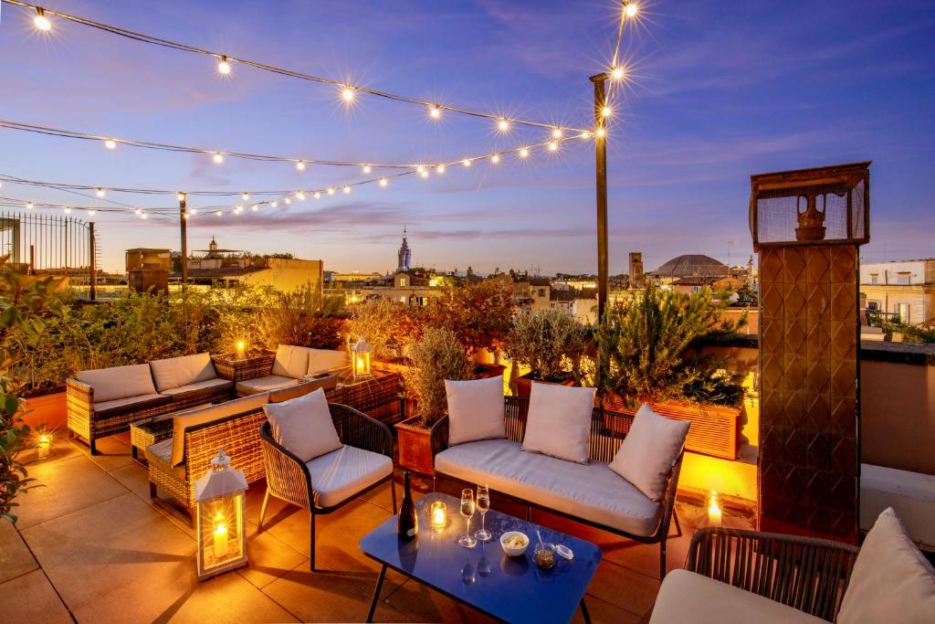 a rooftop patio with lights and chairs and tables at Hotel Della Torre Argentina in Rome