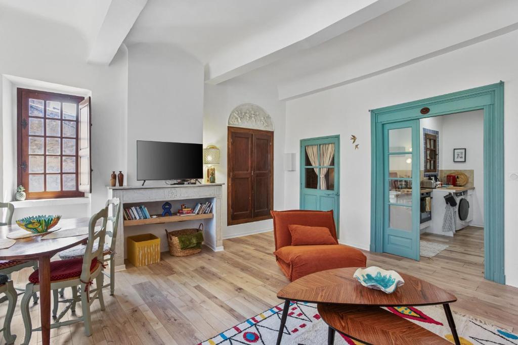 a living room with a table and a tv at Appartement Provençal in Cotignac