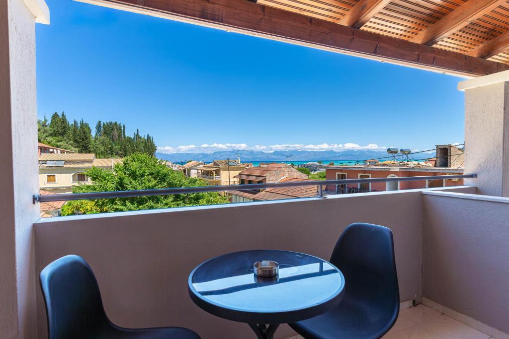 a table and chairs on a balcony with a view at Stay Easy Sidari Apartments in Sidari