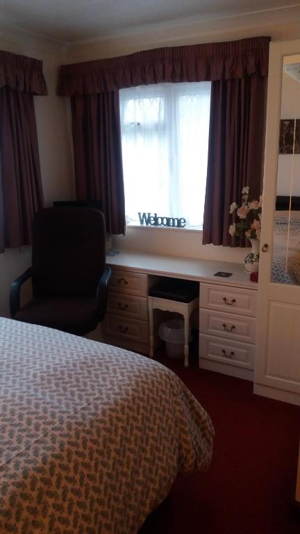 1 dormitorio con cama, escritorio y ventana en Orton Waterville Residence, en Peterborough