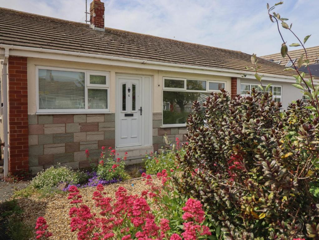 a brick house with a white door and flowers at 6 Bastion Close in Prestatyn