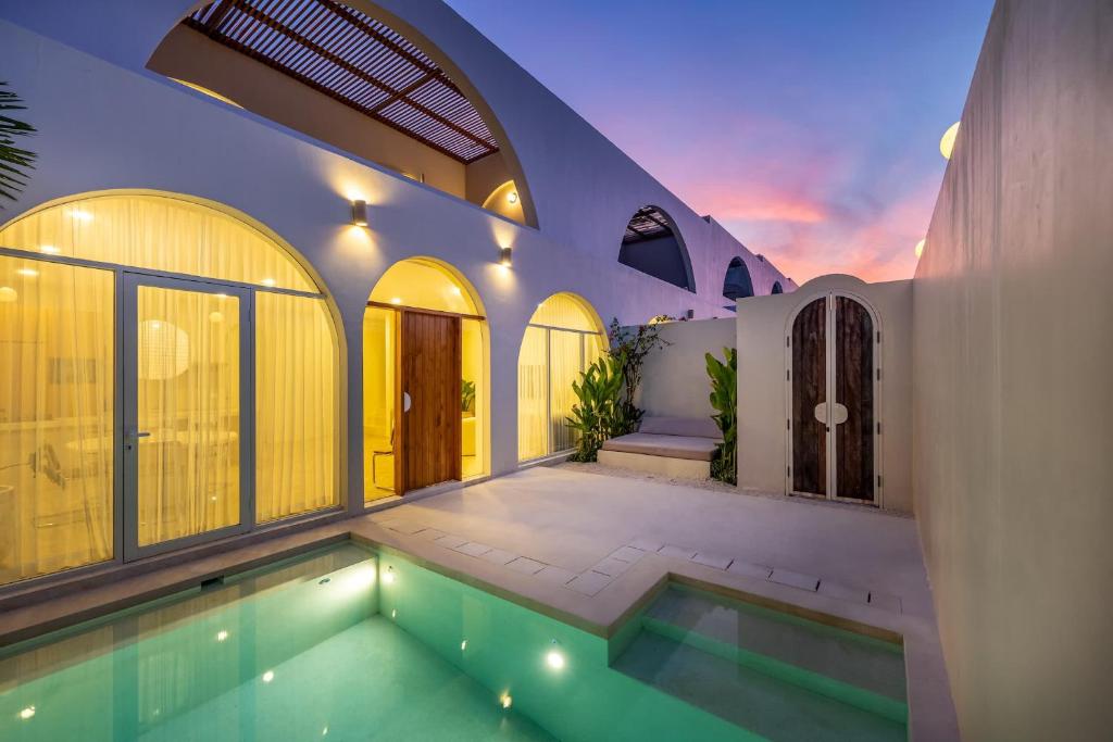 a house with a swimming pool in the middle of it at 2BR Pool Villa Bingin w Ocean View Rooftop - Tasanaa in Badung