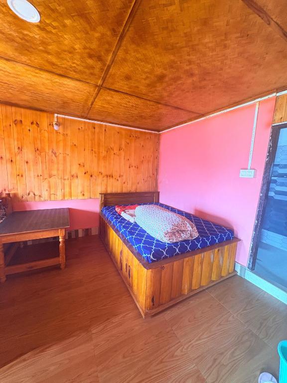 a bedroom with a bed and a bench in a room at Pemazang Homestay in Sombāri
