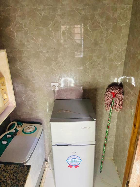 a small kitchen with a washing machine and a broom at Double Homes in Agege