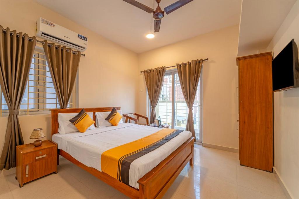 a bedroom with a bed and a flat screen tv at Itsy Hotels Snowdrop in Coimbatore