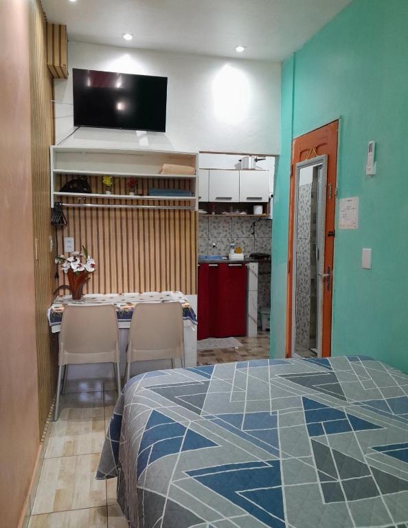 a room with a bed and a kitchen with a table and chairs at Meu refúgio 01 in Belém