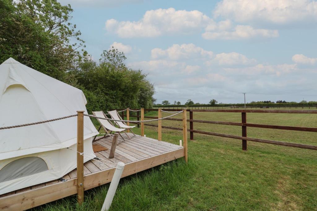a tent sitting on a wooden platform in a field at Bell 3 in Cirencester
