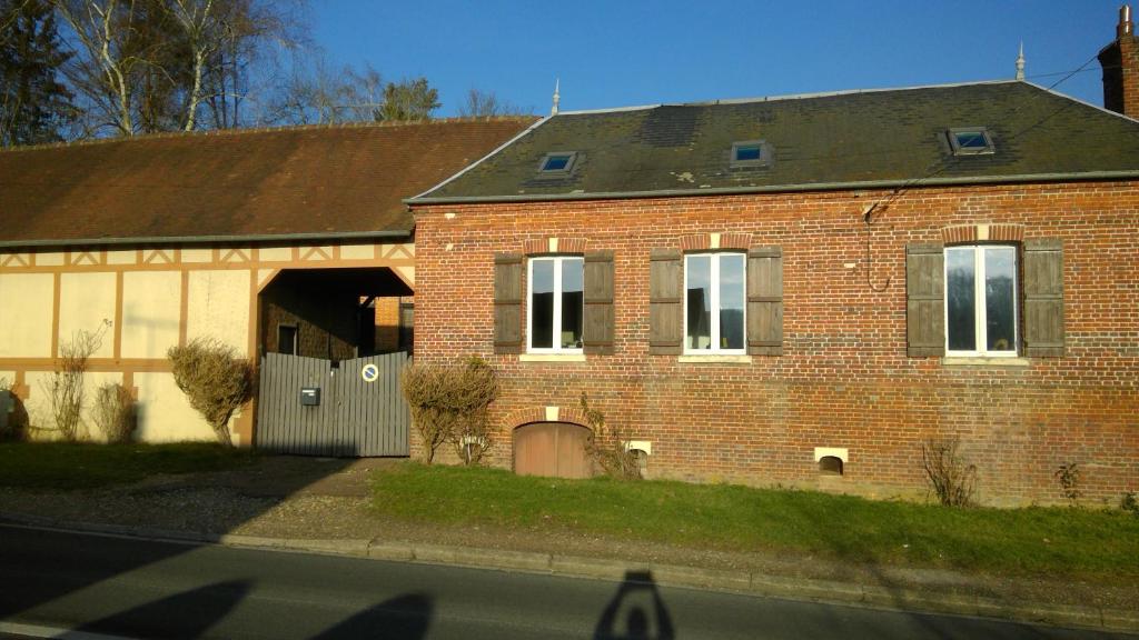 uma casa de tijolos vermelhos com um portão e uma garagem em Chez Tripp em Talmontiers