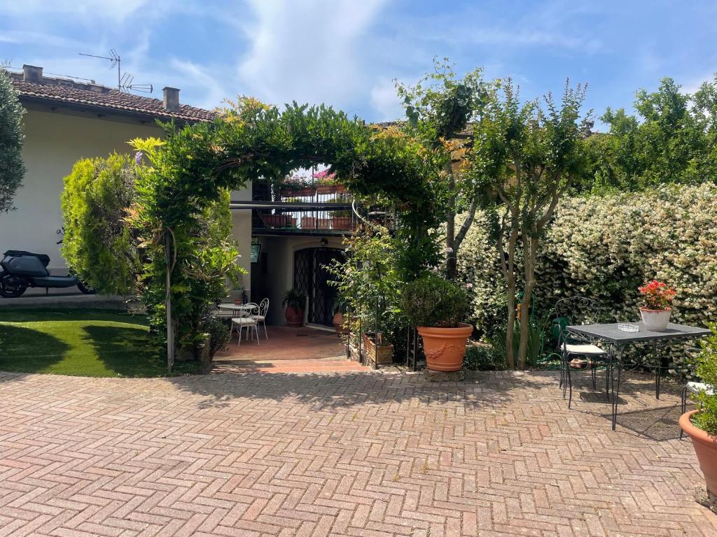 a patio with an arch and tables and plants at Pretty Suite Firenze Fiesole in Florence