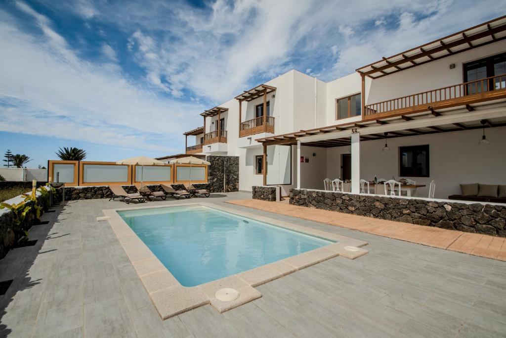 a villa with a swimming pool and a house at Villa Barrilla by Villalize in Tinajo