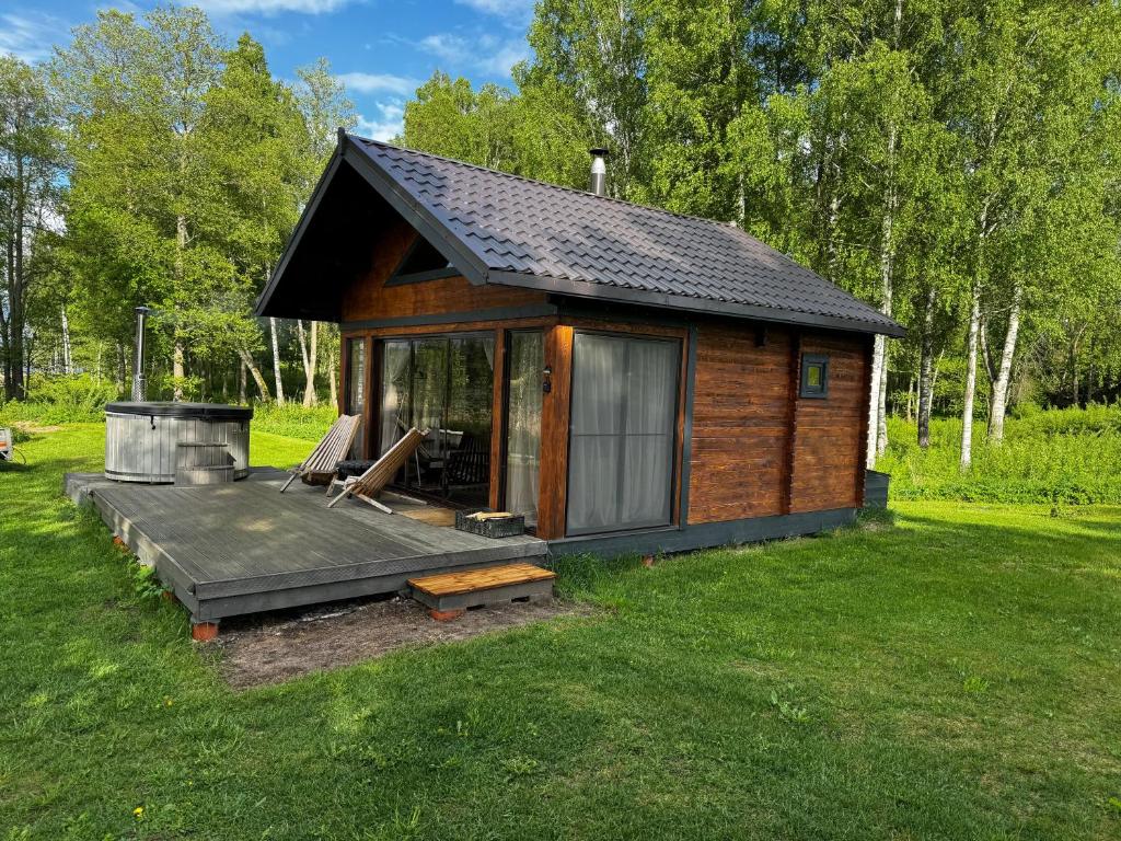 a small cabin with a deck in the grass at Langino Land in Ogureckaja