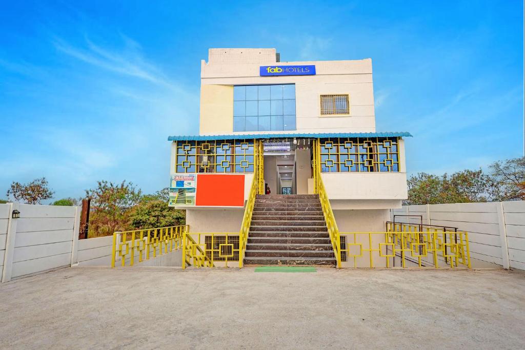 a building with a yellow staircase in front of it at FabHotel Mahi Resort in Aurangabad