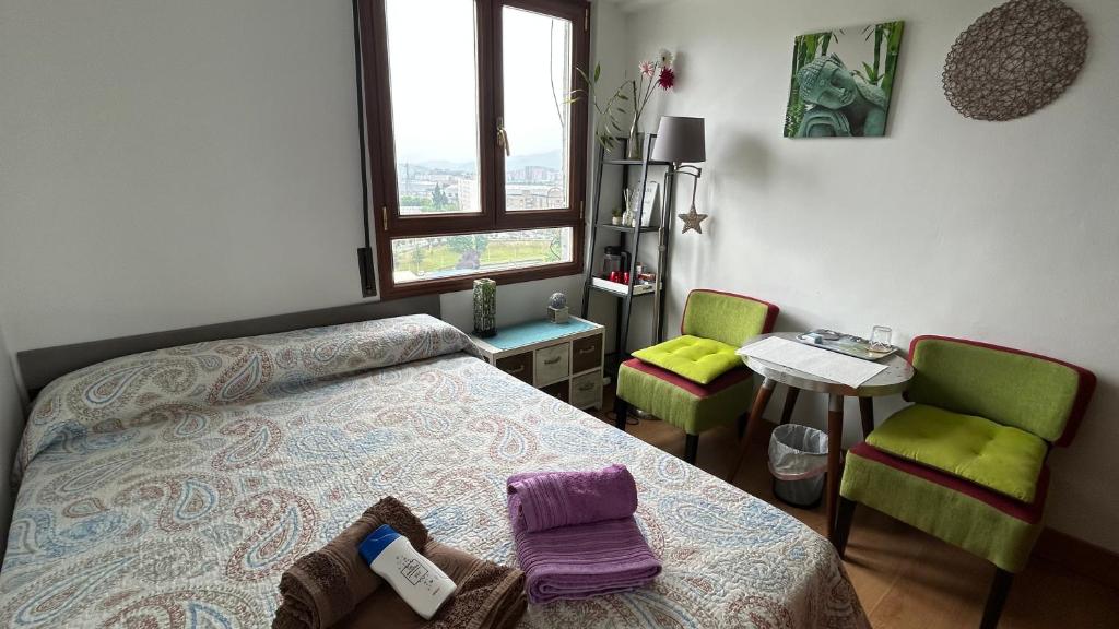 a bedroom with a bed and two chairs and a table at GAIA Hab doble con baño compartido in Bilbao