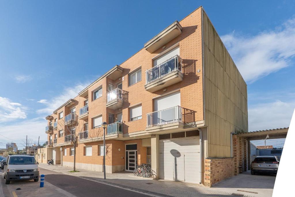a tall brick building with balconies on a street at ELS BALADRES in Deltebre