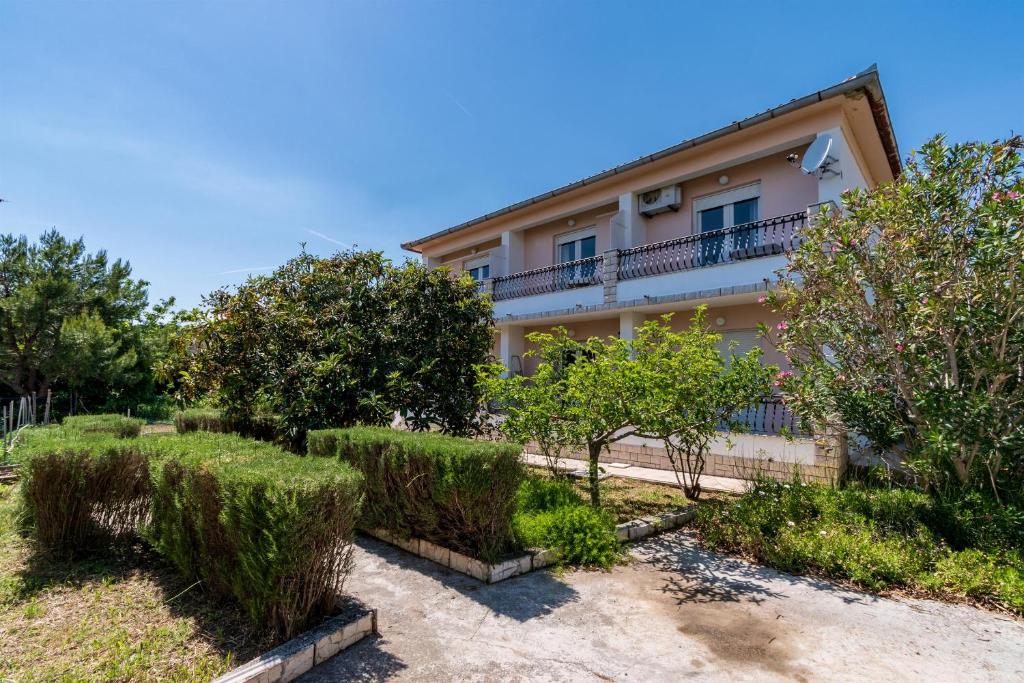 a house with bushes and trees in front of it at Apartments Verdea in Kampor